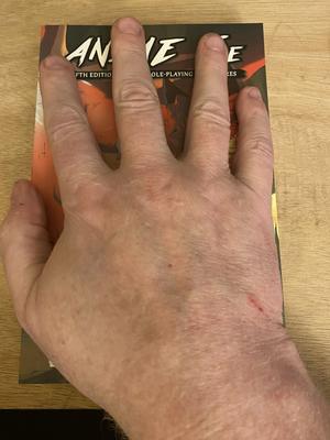 Anime 5E pocket edition with hand for size comparison